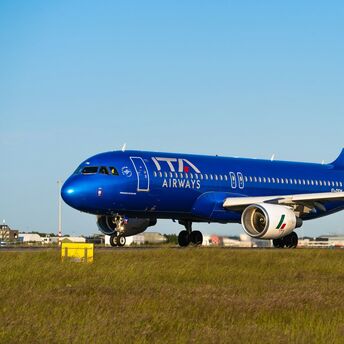 ITA Airways aircraft preparing for departure on a clear day