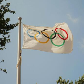 Olympic flag waving against a clear sky