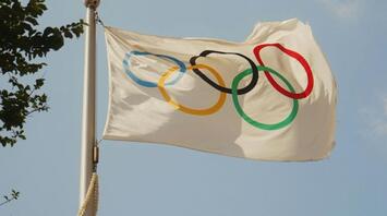 Olympic flag waving against a clear sky