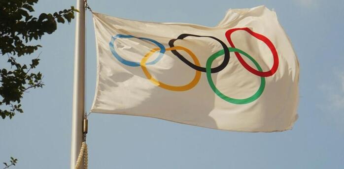 Olympic flag waving against a clear sky