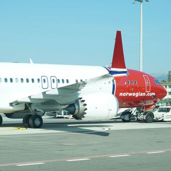 Norwegian aircraft parked on the tarmac during ground operations