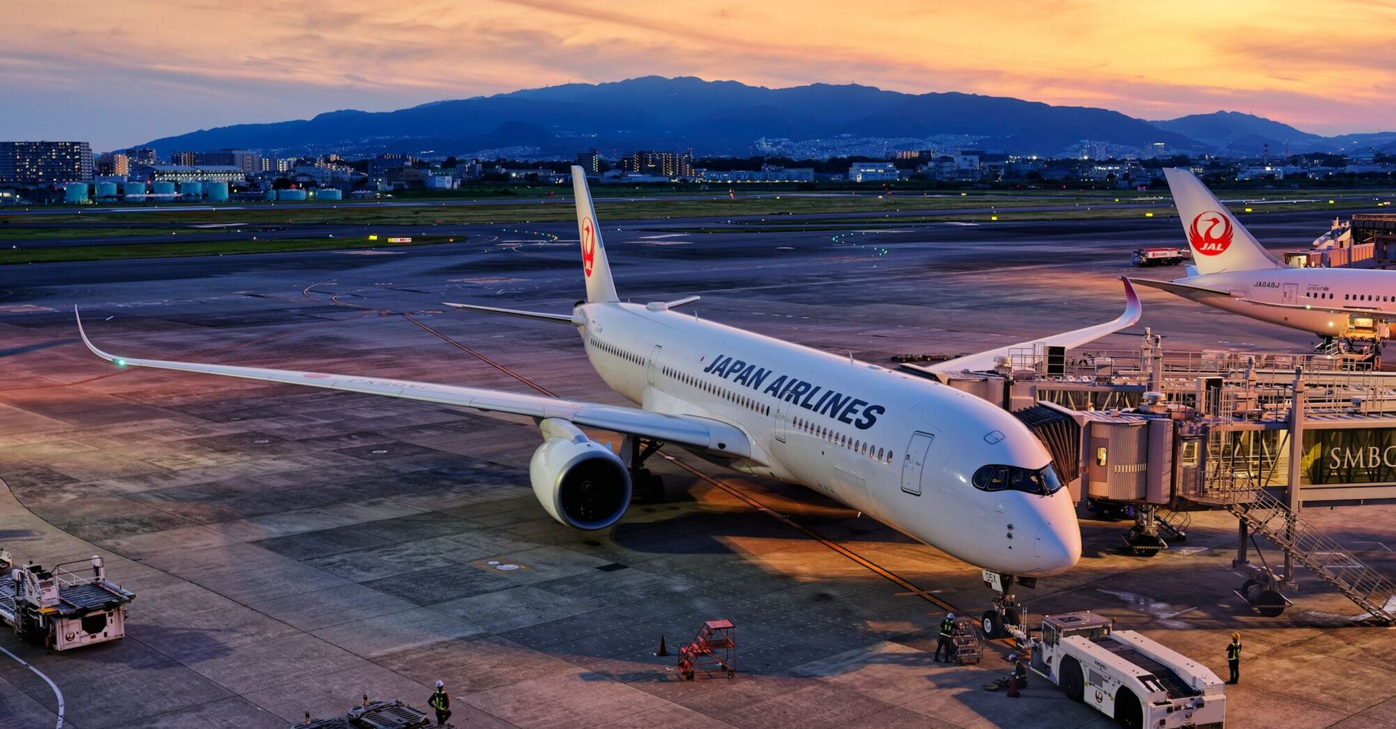 Japan Airlines aircraft preparing for departure at sunset