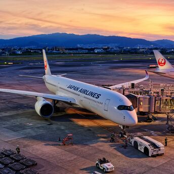 Japan Airlines aircraft preparing for departure at sunset