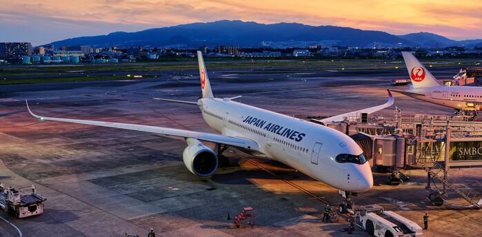 Japan Airlines aircraft preparing for departure at sunset
