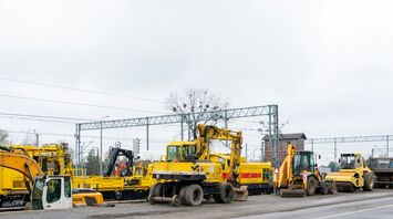 Rail engineering vehicles and machinery parked along a rail line during maintenance work