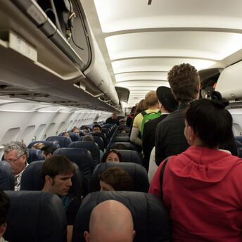 Passengers boarding a crowded aircraft cabin