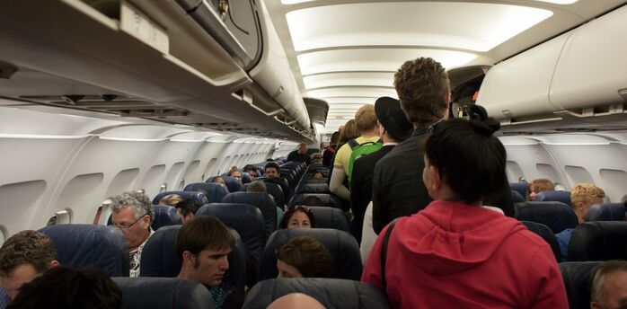 Passengers boarding a crowded aircraft cabin