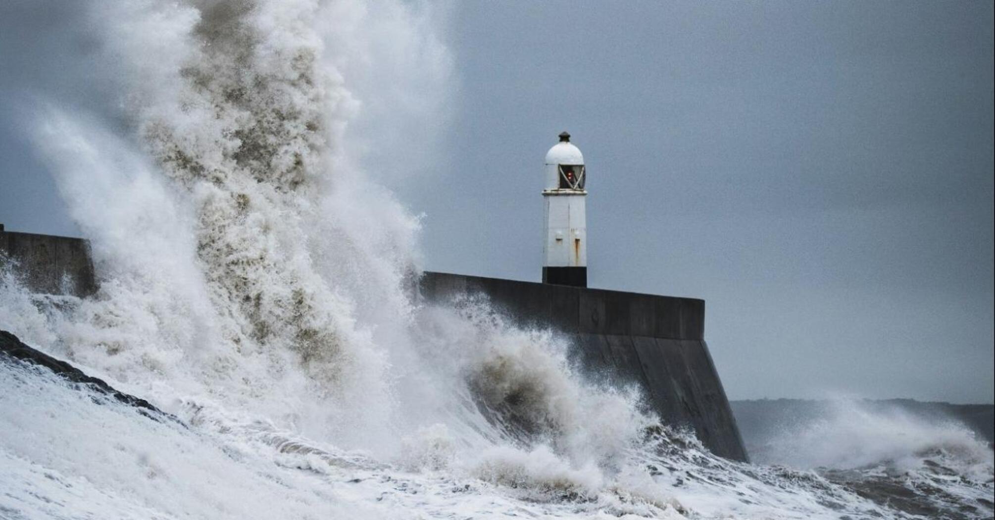 Large waves crashing against a coastal breakwater during stormy weather