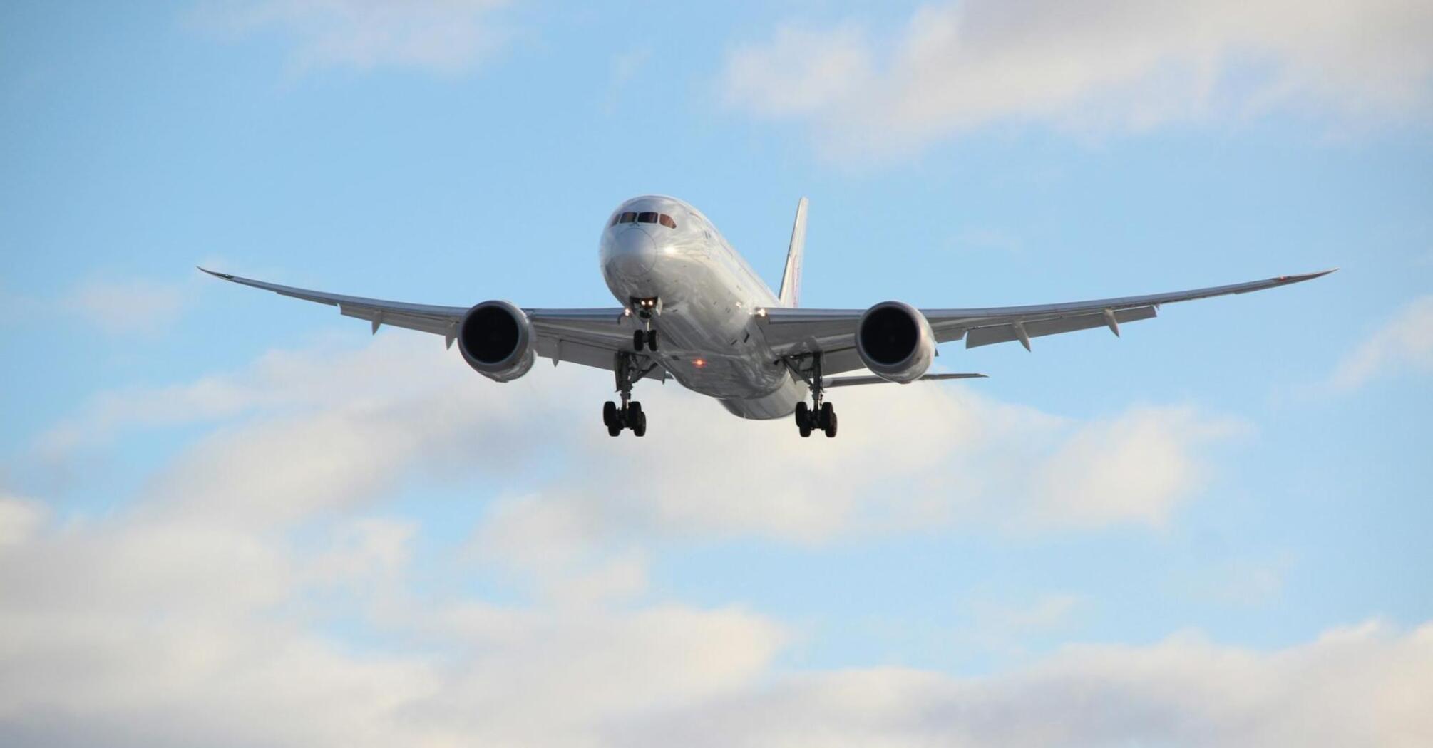 Airplane approaching runway under cloudy sky