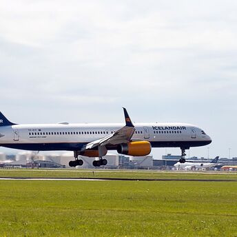 Icelandair aircraft taking off from a runway under cloudy skies