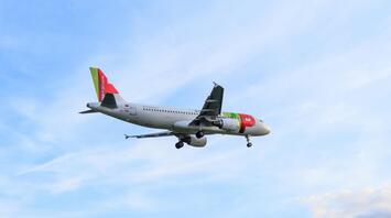 A TAP Air Portugal Airbus A320 flying through a clear sky