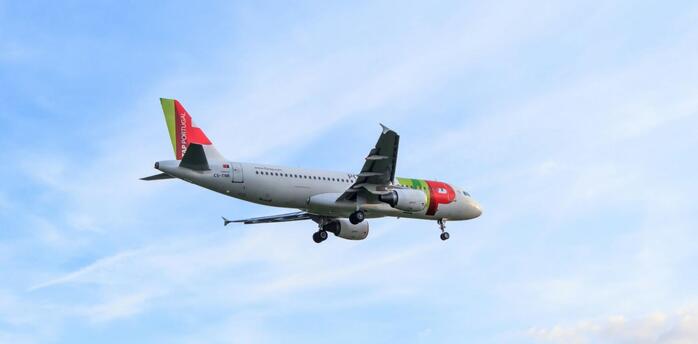 A TAP Air Portugal Airbus A320 flying through a clear sky
