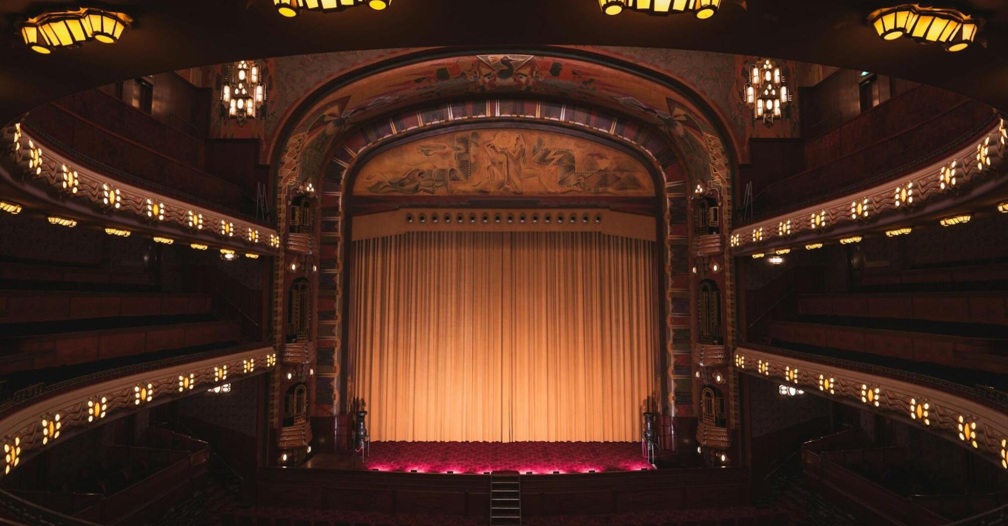 Interior of a historic UK theatre with golden curtains and ornate balconies