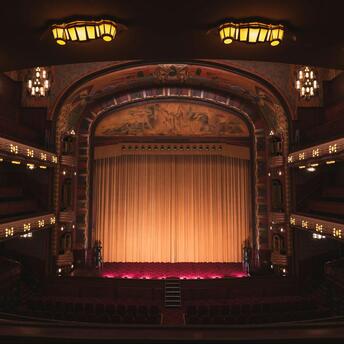 Interior of a historic UK theatre with golden curtains and ornate balconies