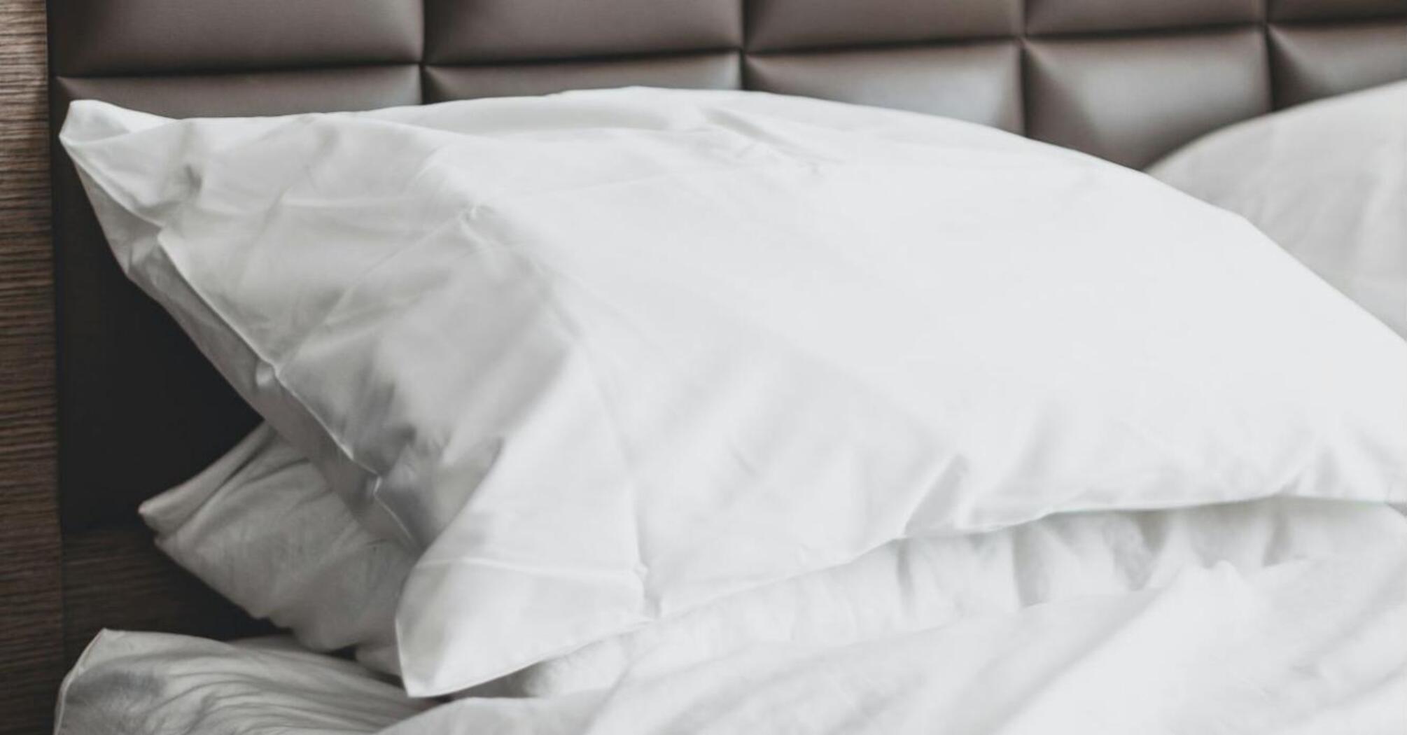Neatly made hotel bed with white linens