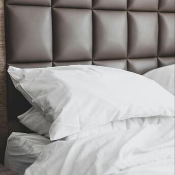Neatly made hotel bed with white linens