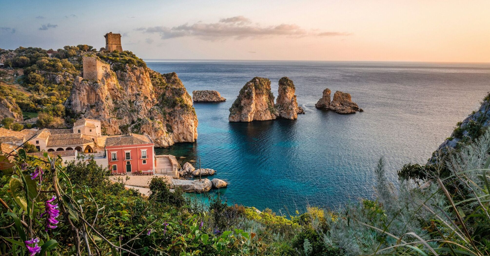 Coastal village and rocky cliffs in Sicily at sunset