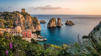 Coastal village and rocky cliffs in Sicily at sunset