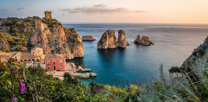 Coastal village and rocky cliffs in Sicily at sunset
