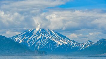Snow-covered volcano on the Kamchatka Peninsula emitting a plume of smoke