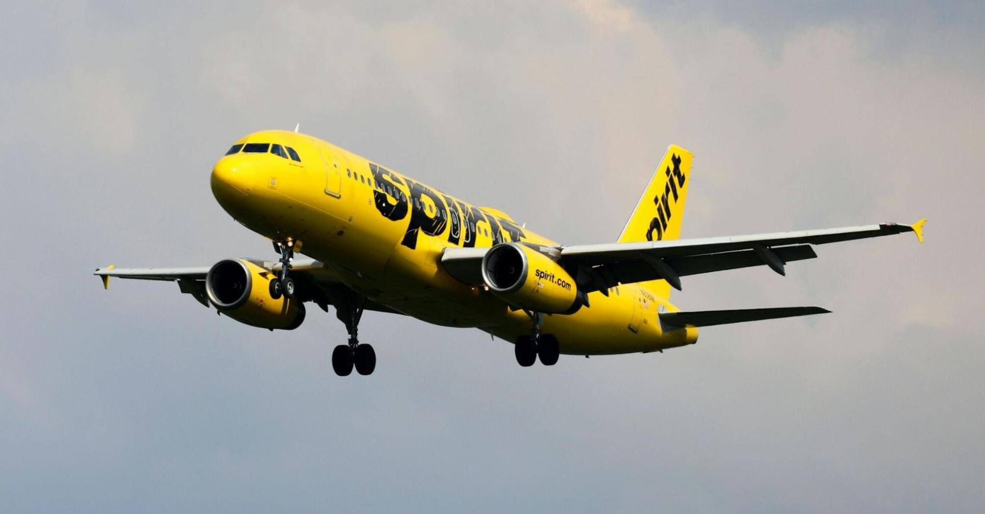 Spirit Airlines aircraft preparing to land under cloudy skies
