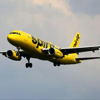 Spirit Airlines aircraft preparing to land under cloudy skies