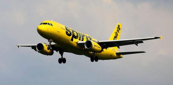 Spirit Airlines aircraft preparing to land under cloudy skies