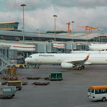 Philippine Airlines aircraft parked at the gate during cloudy weather