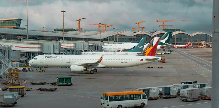 Philippine Airlines aircraft parked at the gate during cloudy weather