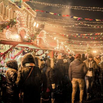 Crowds enjoy festive lights and stalls at a European Christmas market