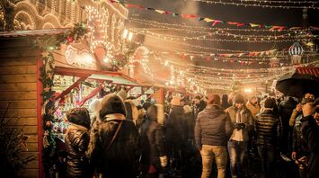 Crowds enjoy festive lights and stalls at a European Christmas market