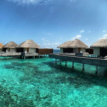 Overwater villas on a clear lagoon in the Maldives
