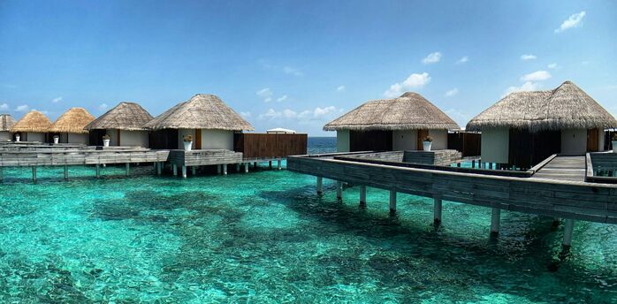 Overwater villas on a clear lagoon in the Maldives