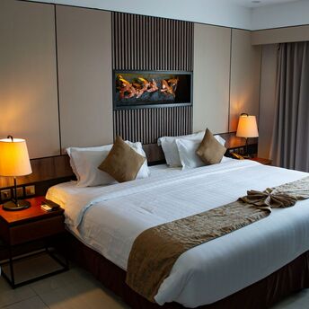 Modern hotel room with a large double bed and soft lighting