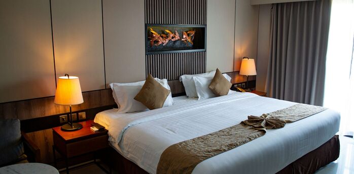 Modern hotel room with a large double bed and soft lighting