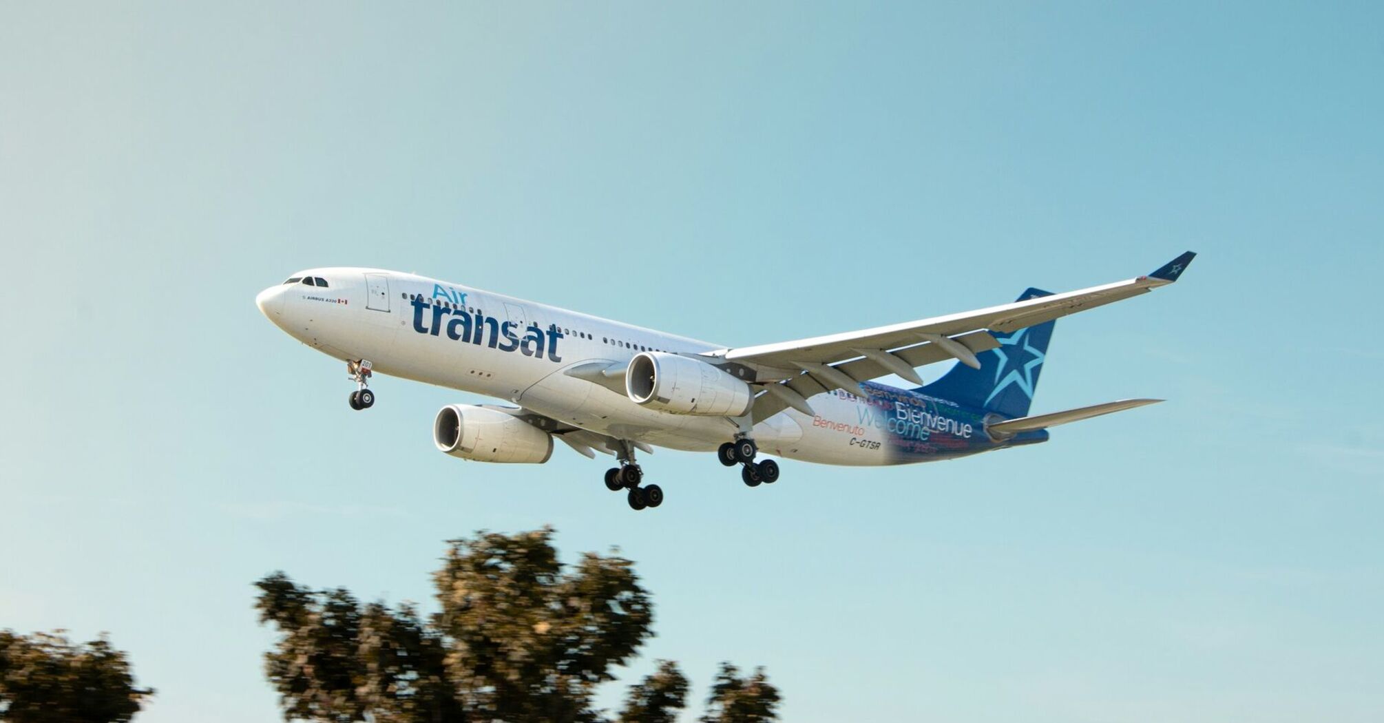 Air Transat aircraft approaching for landing against a clear sky