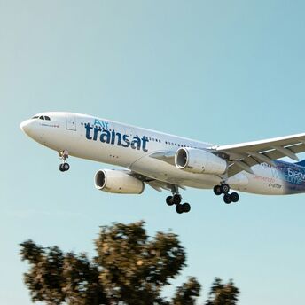 Air Transat aircraft approaching for landing against a clear sky