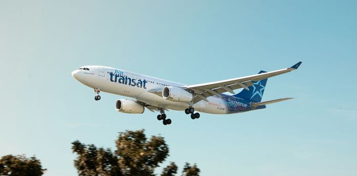 Air Transat aircraft approaching for landing against a clear sky