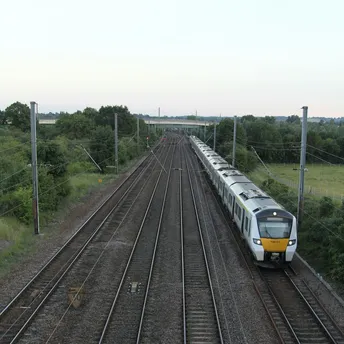 Passenger train travelling along multi-track railway through rural Norfolk