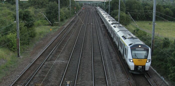 Passenger train travelling along multi-track railway through rural Norfolk