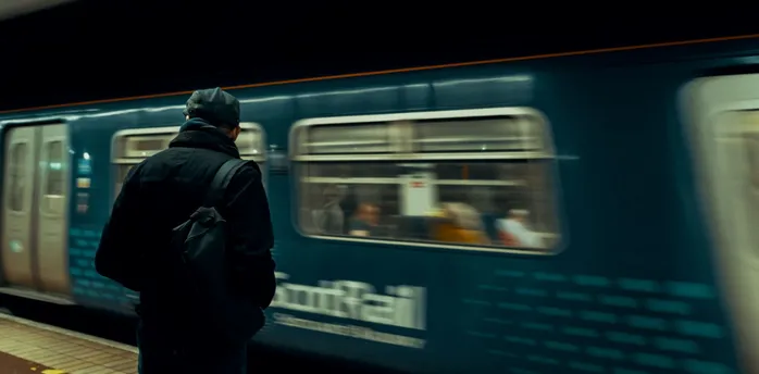 Passenger waiting on a ScotRail platform as a train arrives