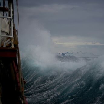 Large storm waves hitting a vessel during severe weather