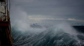 Large storm waves hitting a vessel during severe weather