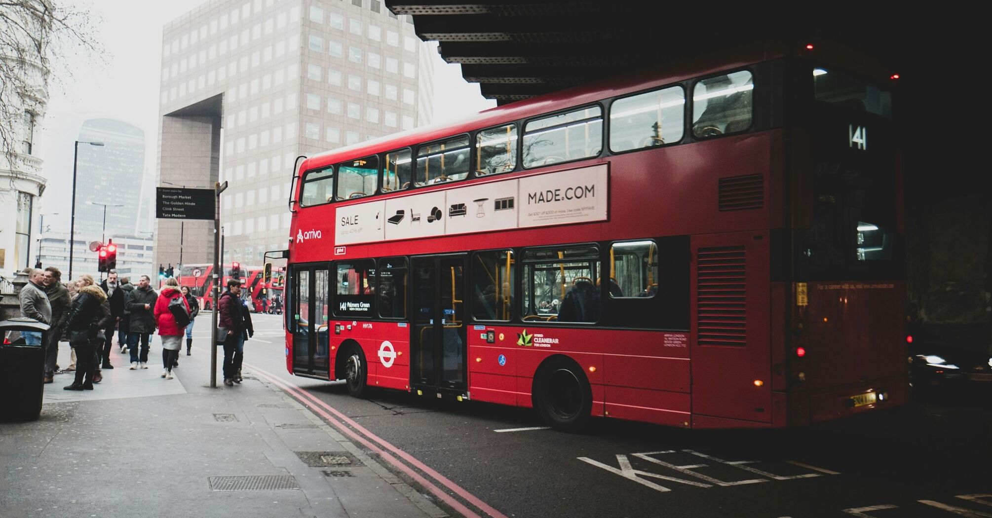 Red double decker bus stopping for passengers