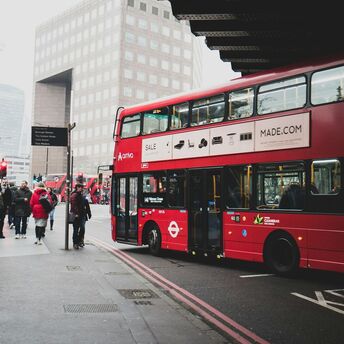 Red double decker bus stopping for passengers