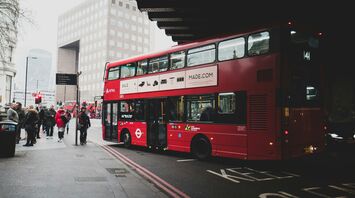 Red double decker bus stopping for passengers