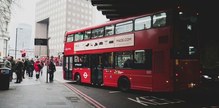 Red double decker bus stopping for passengers