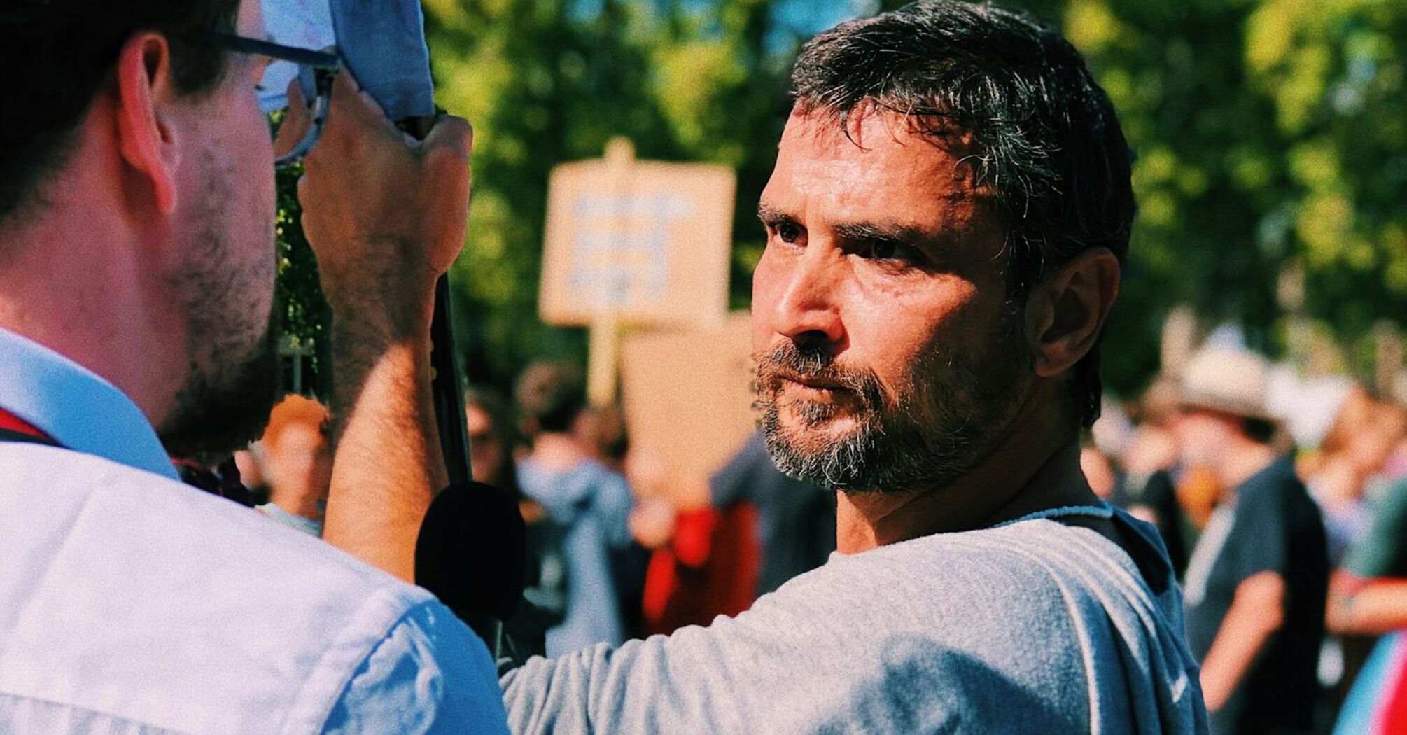 A man speaks to a reporter during a public strike gathering