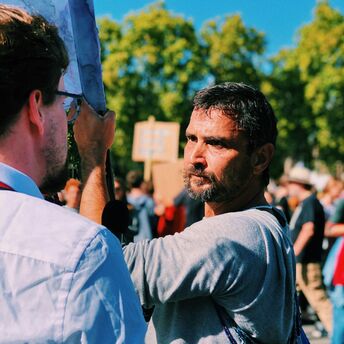 A man speaks to a reporter during a public strike gathering