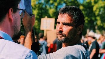 A man speaks to a reporter during a public strike gathering
